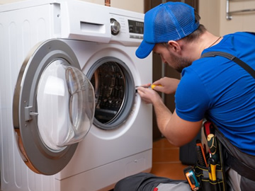 Técnico executando manutenção em máquina de lavar roupas